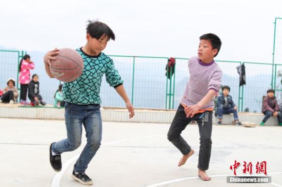 资料图：2月20日，贵州省榕江县高岜苗寨高扒小学学生在课间打篮球。贺俊怡 摄
