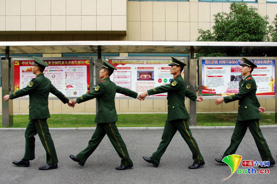 图为中队官兵走过三块十九大主题展板.中国青年网见习记者 张潼 摄