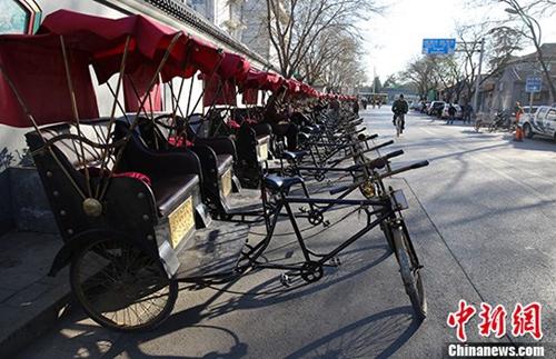 资料图：北京什刹海附近胡同里的“人力三轮车”停靠在路边，排成一排。<a target='_blank' href='http://www.chinanews.com/' _fcksavedurl='http://www.chinanews.com/'></table>中新社</a>发 熊然 摄