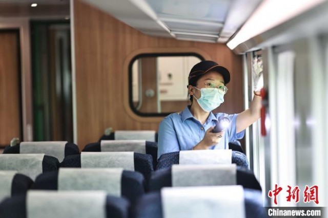 何丽娟正在检查列车设备。　苏志刚 摄