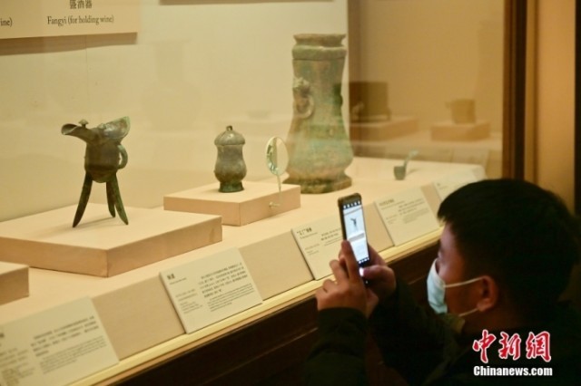 资料图：中国国家博物馆“中国古代饮食文化展”上新并恢复对公众展出，参观者拍摄商代的饮酒器铜爵。<a target='_blank'  data-cke-saved-href='/' href='/'><p  align=
