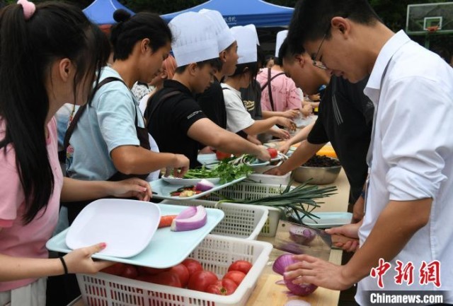 活动现场，大学生正在挑选新鲜蔬菜进行制作。　周毅 摄