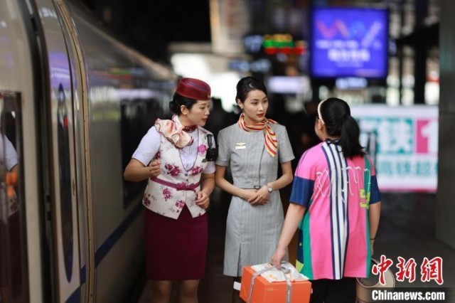 图为重庆客运段乘务员和西部航空乘务员一起在站台上引导旅客乘车。　苏志刚 摄
