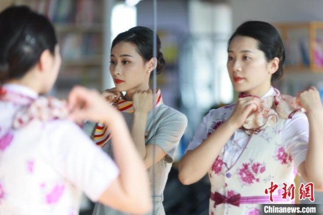 图为重庆客运段乘务员和西部航空乘务员一起整理妆容。　苏志刚 摄