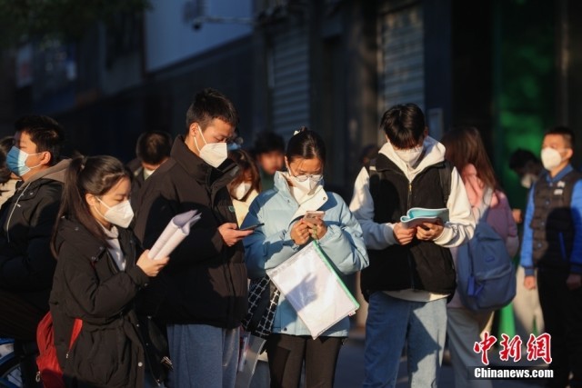 1月8日，江西南昌市第二十八中学考点外，几名考生在复习。当日，中央机关及其直属机构2023年度考试录用公务员公共科目笔试举行。<a target='_blank' href='/'><p  align=