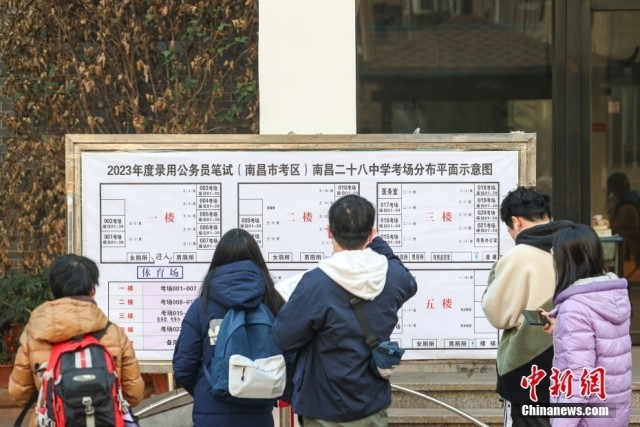 1月8日，江西南昌市第二十八中学考点，几名考生在察看考场安排表。当日，中央机关及其直属机构2023年度考试录用公务员公共科目笔试举行。<a target='_blank' href='/'><p  align=