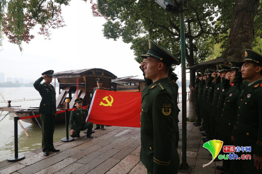 图为武警桐乡中队官兵在嘉兴南湖边,面对红船,面对党旗重温入党适词