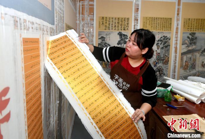 图为：陈雨正在拆画。　吕明 摄